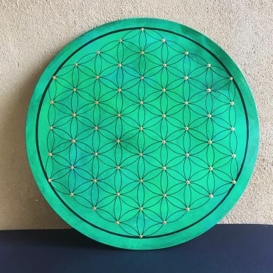 Disque vert ornée de motifs géométriques et de points colorés.