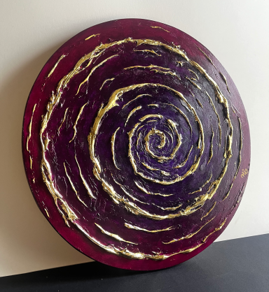 Cercle en relief aux spirales dorées sur fond rouge-violet.